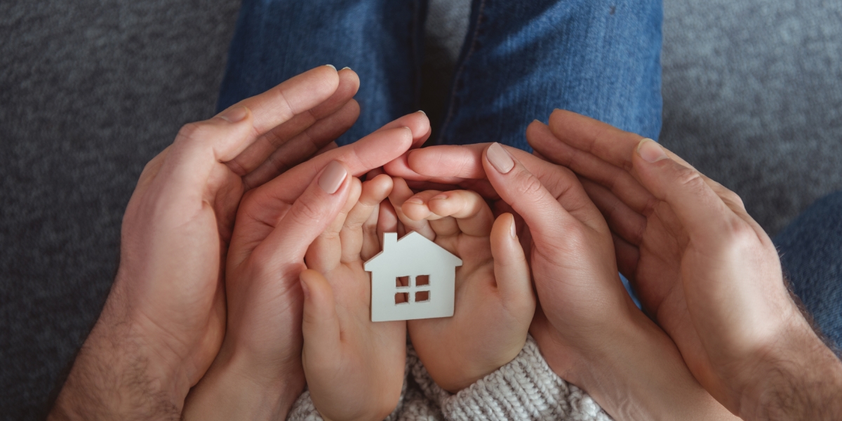 cropped-shot-of-family-holding-small-house-model-i-2026-01-06-00-38-25-utc